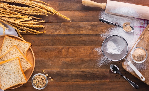 Pão cozido na bandeja de madeira e ingrediente para cozido, vista superior, com espaço de cópia