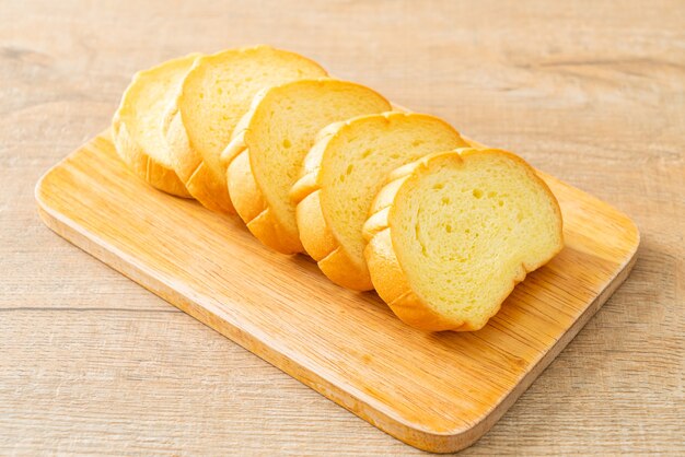 Pão de batata doce fatiado em tábua de madeira