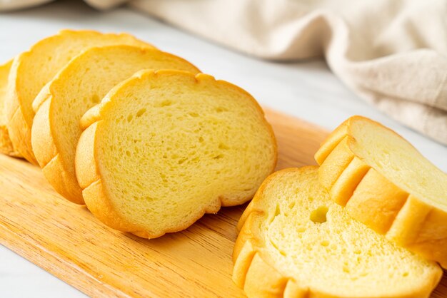 Pão de batata doce fatiado em tábua de madeira