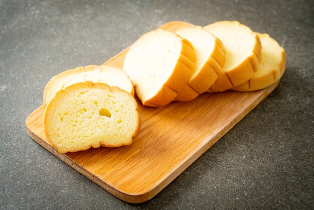 Pão de batata doce fatiado em tábua de madeira