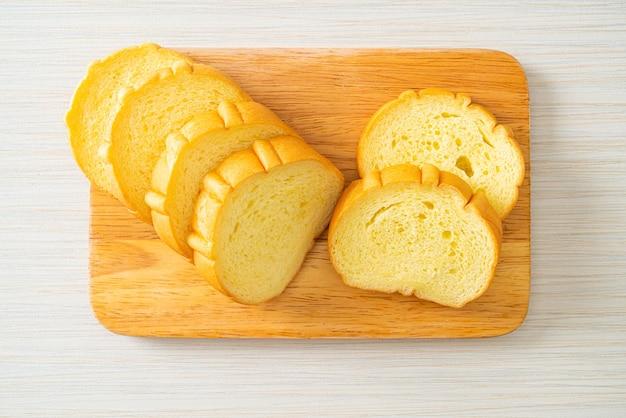 Pão de batata doce fatiado em tábua de madeira