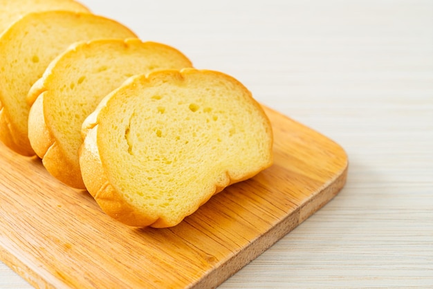 Pão de batata doce fatiado em tábua de madeira