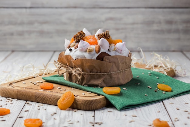 Pão de bolo de páscoa decorado com damascos secos doces e sementes de girassol no conceito de férias de fundo de madeira