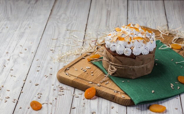 Pão de bolo de páscoa decorado com damascos secos doces e sementes de girassol no conceito de férias de fundo de madeira