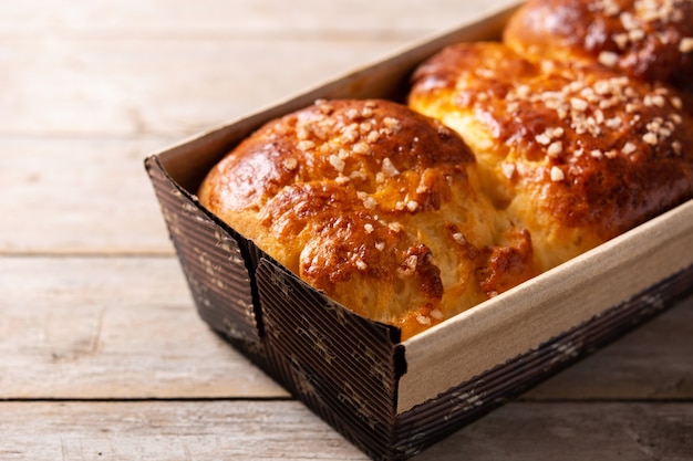 Pão de brioche assado trançado na mesa de madeira