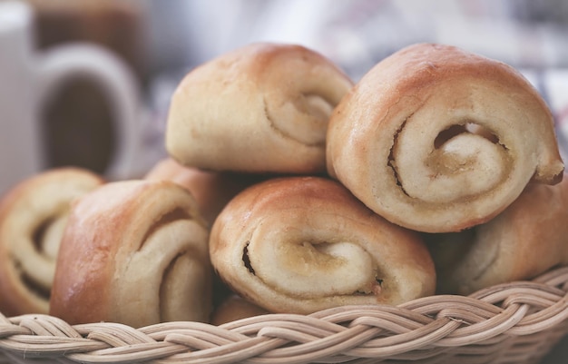 Pão de canela enrolado, um lanche popular, acompanhado de café