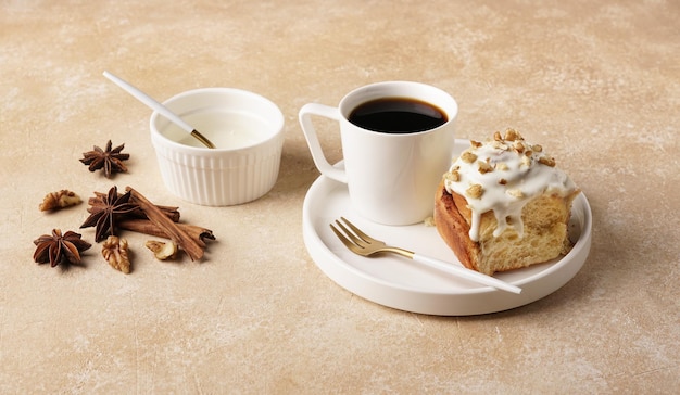 Pão de canela recém-assado com especiarias e recheio de cacau e café em prato branco sobre fundo de mármore marrom Café da manhã sueco