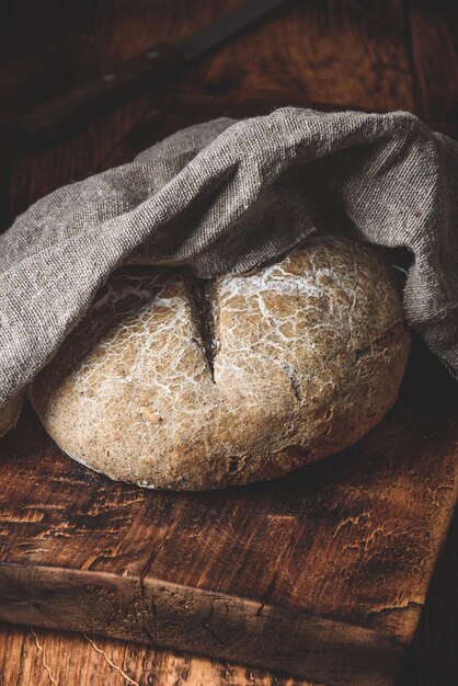 Foto pão de centeio recém-cozido na prancha de corte