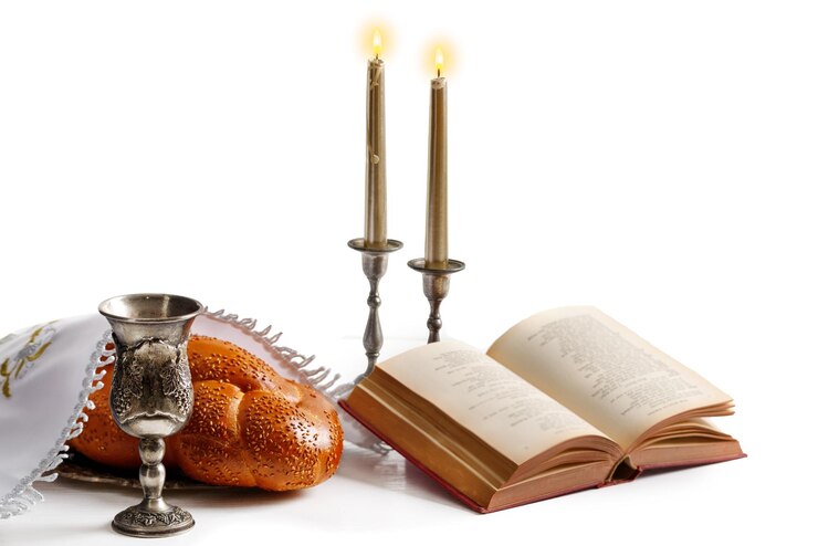 Foto pão de chalá coberto com um guardanapo especial vinho shabbat torá e velas em fundo branco ritual judaico tradicional de shabbat shabbat shalom