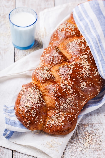 Pão de chalá com sementes de gergelim e um copo de leite