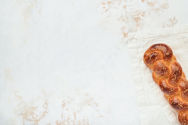 Pão de chalá Composição de cerimônia de kidush de sábado Pão de chalá trançado caseiro recém-assado para Shabat e feriados em fundo branco Shabat Shalom Vista superior Copiar espaço