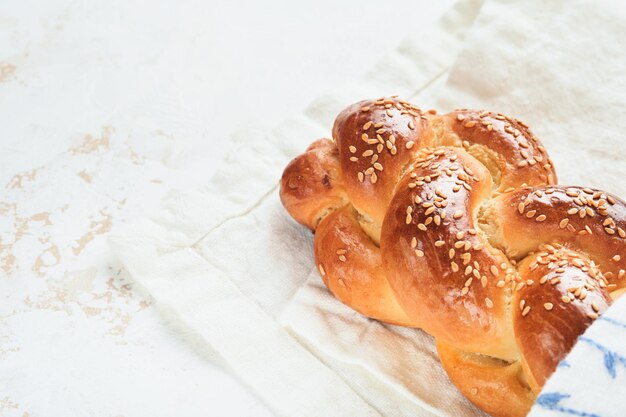 Pão de chalá Composição de cerimônia de kidush de sábado Pão de chalá trançado caseiro recém-assado para Shabat e feriados em fundo branco Shabat Shalom Vista superior Copiar espaço