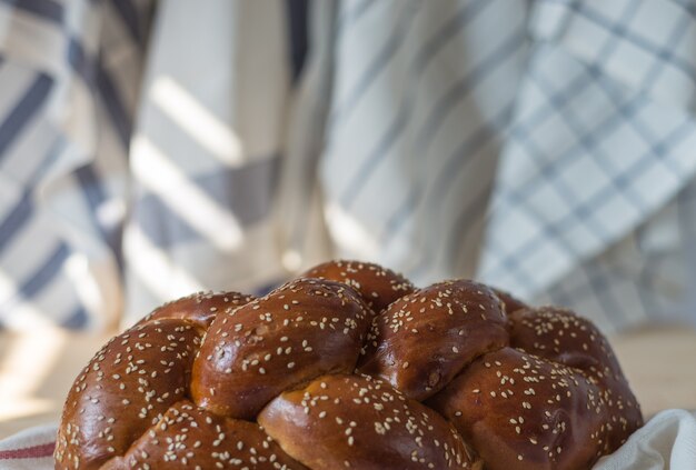 Foto pão de chalá ou pão judeu tradicional em uma placa de madeira na mesa de madeira