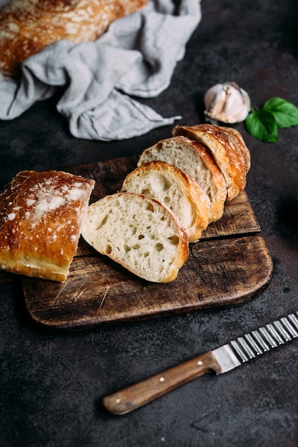 Pão de ciabatta caseiro Fatias de pão em fatias de tábua de madeira Pão