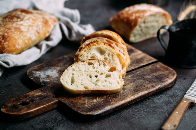 Pão de ciabatta caseiro Fatias de pão em fatias de tábua de madeira Pão