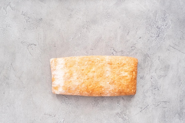 Pão de ciabatta recém-assado na mesa cinza.