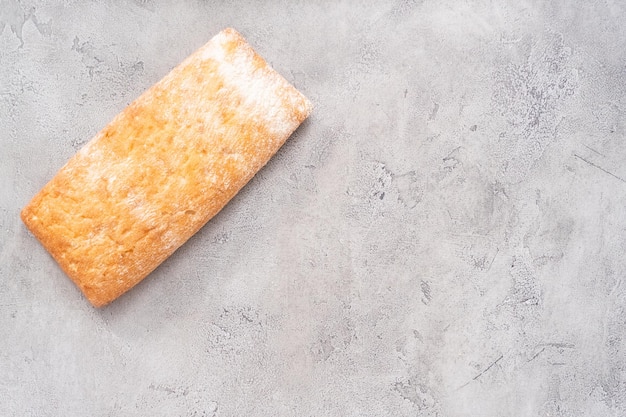 Pão de ciabatta recém-assado na mesa cinza.