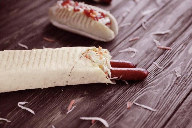 Pão de fast foodpita com salsicha e cachorro-quente em fundo escuro