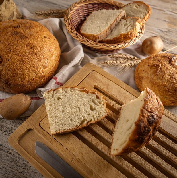 Pão de fermento tradicional cortado em fatias em uma prancha de madeira rústica