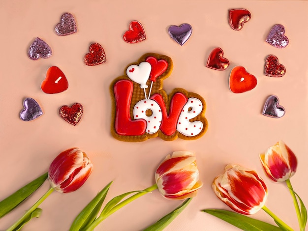 Pão de gengibre na forma da palavra amor corações decorativos flores de tulipa