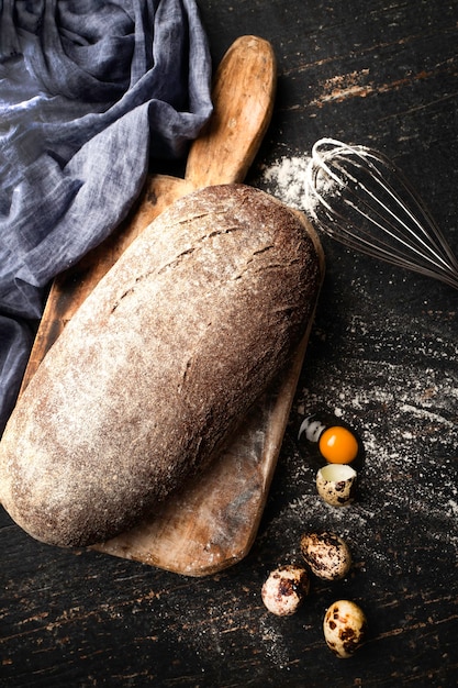 Pão de grãos recém-assado em uma velha tábua de cortar