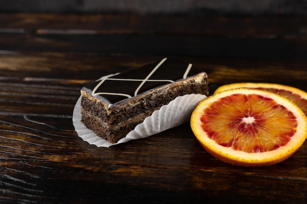 Pão de ló em cobertura de chocolate com dois pratos de laranja vermelha