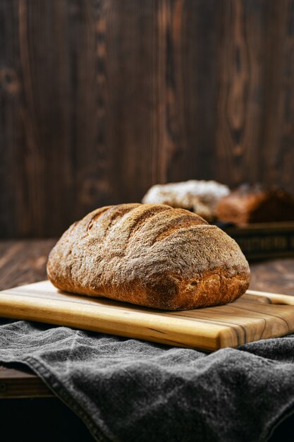 Pão de massa fermentada artesanal com textura porosa na mesa de madeira