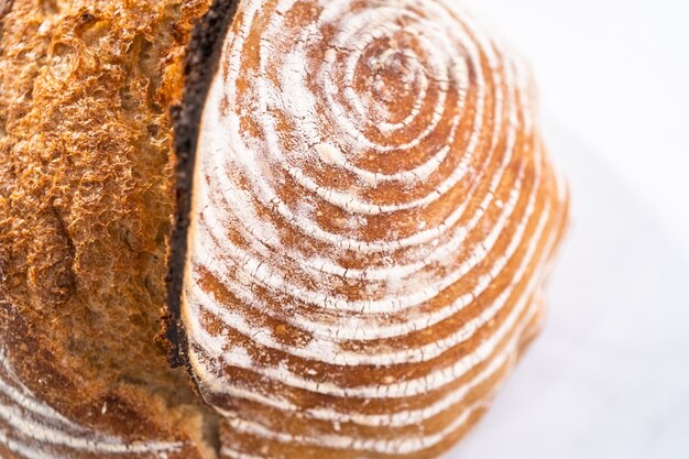 Pão de massa fermentada de trigo recém-assado com marcas da cesta de impermeabilização do pão.