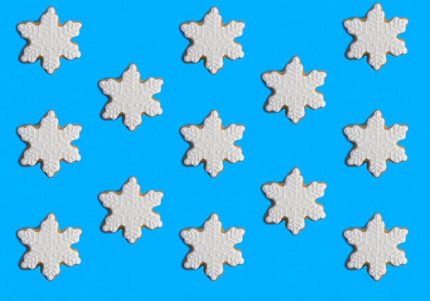 Pão de Natal em forma de flocos de neve no fundo azul Padrão Flat lay