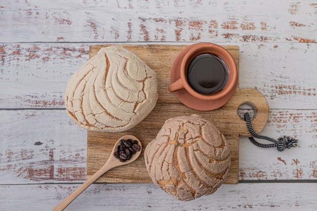 Pão de padaria caseiro doce tradicional doce e pastelaria, xícara de barro de café e colher de madeira