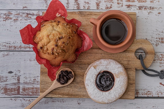 Pão de padaria caseiro doce tradicional doce e pastelaria, xícara de barro de café e colher de madeira