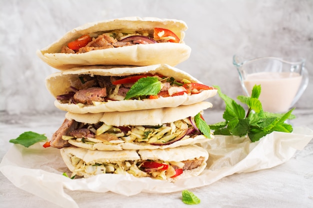 Pão de pita de carne com molho de iogurte e folhas de hortelã