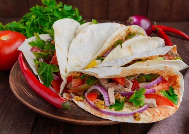 Pão de pita oriental com vários recheios (carne, salame, ovo, pepino, salsa, tomate, pimenta malagueta, mostarda de Dijon). Taco.