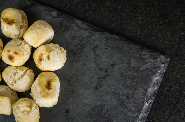 Pão de queijo delicioso na mesa escura. comida tradicional mineira.