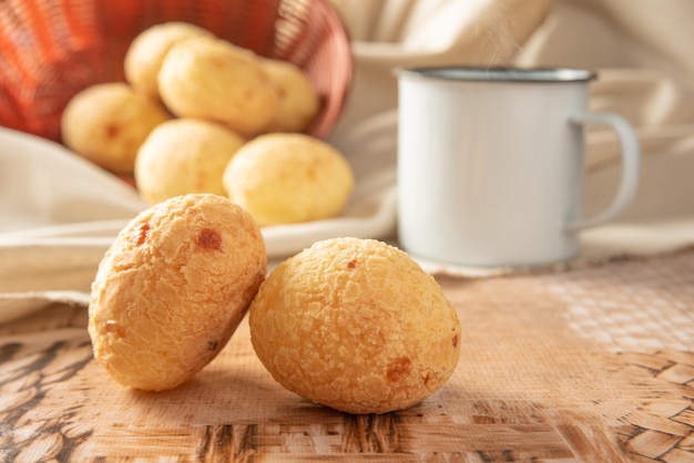 Foto pão de queijo do brasil, arranjo com pão de queijo, tecido e acessórios na mesa