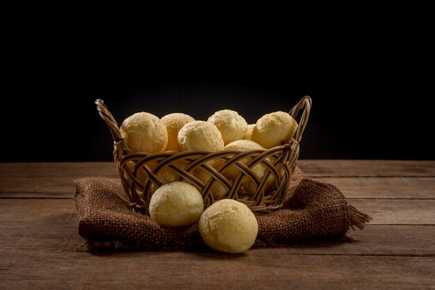 Pão de queijo, lanche caseiro tradicional brasileiro (pão de queijo) na mesa de madeira rústica.