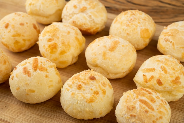 Foto pão de queijo típico brasileiro sobre tábua de madeira