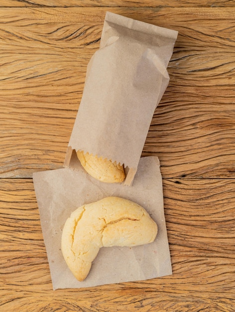 Pão de queijo típico da América do Sul Chipas em um saco de papel sobre a mesa de madeira