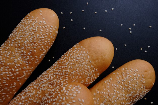 Foto pão de sementes de gergelim no chão preto