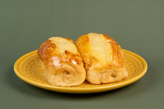 Pão doce brasileiro de padaria na placa amarela e fundo verde