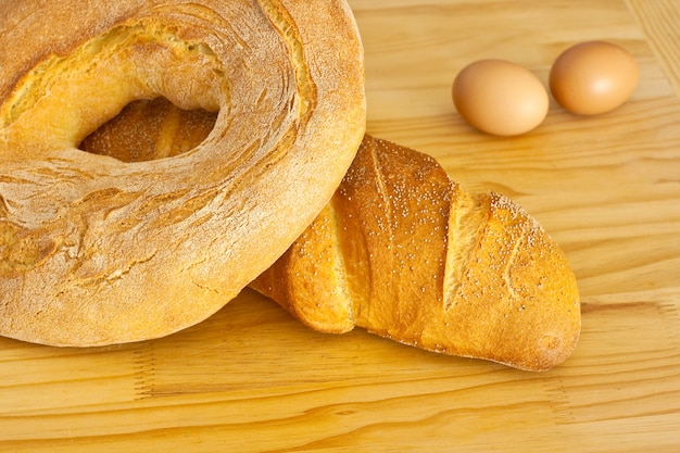 Pão e ovos em fundo de madeira