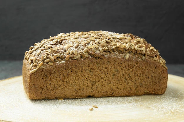 Pão escuro fresco Pão de centeio no tabuleiro Pão de centeio integral com sementes Alimentação saudável Espaço para cópia