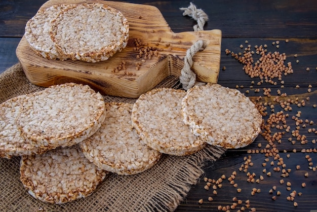 Pão estaladiço arejado, redondo e crocante de trigo sarraceno em fundo de madeira