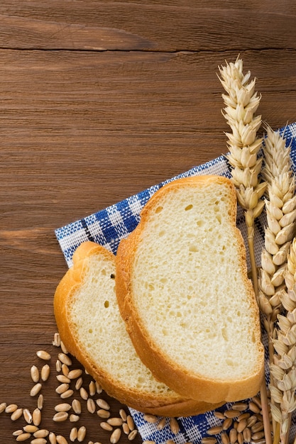 Pão fatiado e espigas de trigo no guardanapo