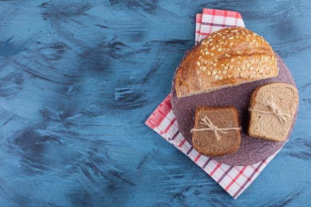 Pão fatiado em um prato na toalha, na mesa azul.