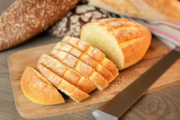 Pão fatiado na mesa em um fundo de vários pães.