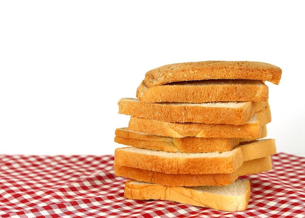 Pão fatiado no fundo da toalha de mesa xadrez vermelha