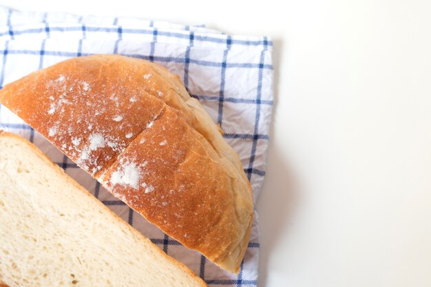 Pão feito home fresco no fundo branco da tabela com guardanapo.