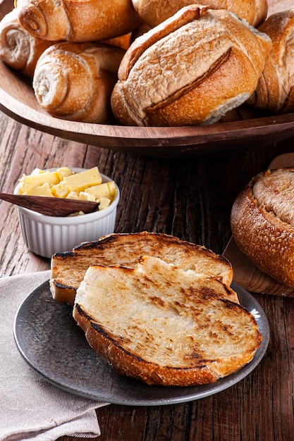 Pão francês cortado ao meio e tostado com manteiga