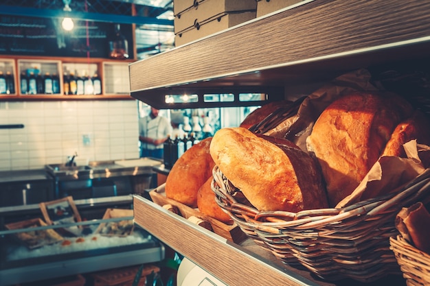 Pão francês fresco na cozinha da loja do restaurante, deitado no balcão da loja. conceito de comida. filtro de cor brilhante.